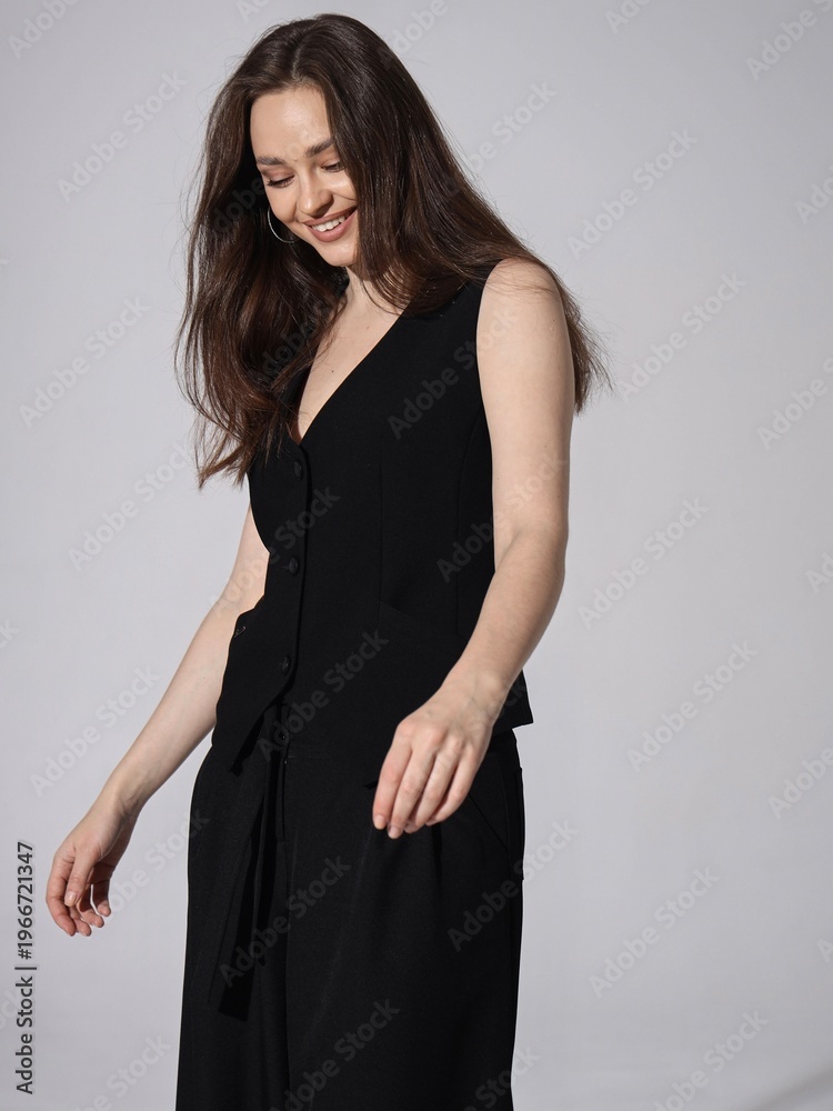 Naklejka premium Elegant Woman Wearing a Stylish Vest and Pants Exudes Confidence and Grace in a Minimalist Fashion Setting with a Soft Background