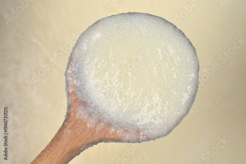 Tableau sur toile A wooden spoon holds a portion of warm creamy semolina porridge cooked with milk