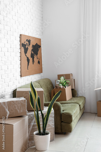 Sofa with cardboard boxes in office on moving day