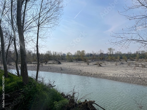 River Po Landscape: A serene river flows through a scenic landscape with trees, capturing the essence of tranquility and the beauty of natural world.