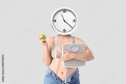Overweight woman with clock...
