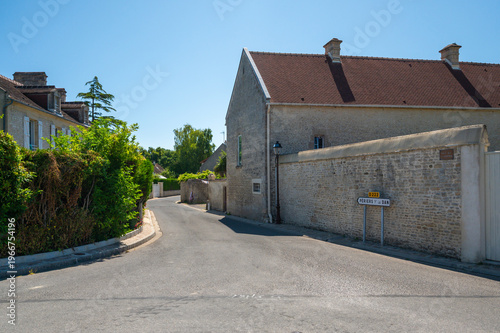 Quiet Normandy village street with road sign to Periers-sur-le-Dan