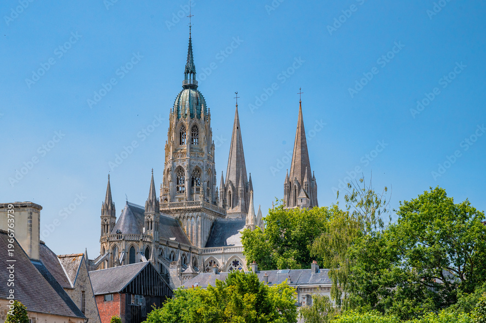 Obraz premium Close view of Bayeux Cathedral spires through trees Normandy