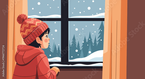 Young child wearing a red hat and hoodie gazes out a window at a winter snowfall and evergreen forest