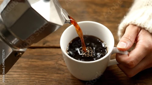 Pouring Freshly Brewed Coffee into a White Mug on a Wooden Table.