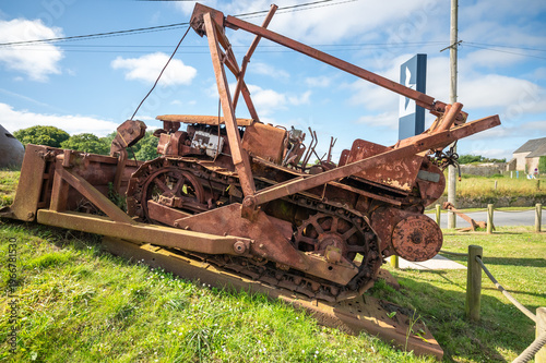 Rusted WWII bulldozer wreck on grassy roundabout Normandy France