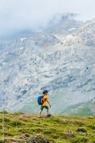 Traveling child. a tourist with a backpack walks along a mountain road. hiking and active healthy lifestyle.