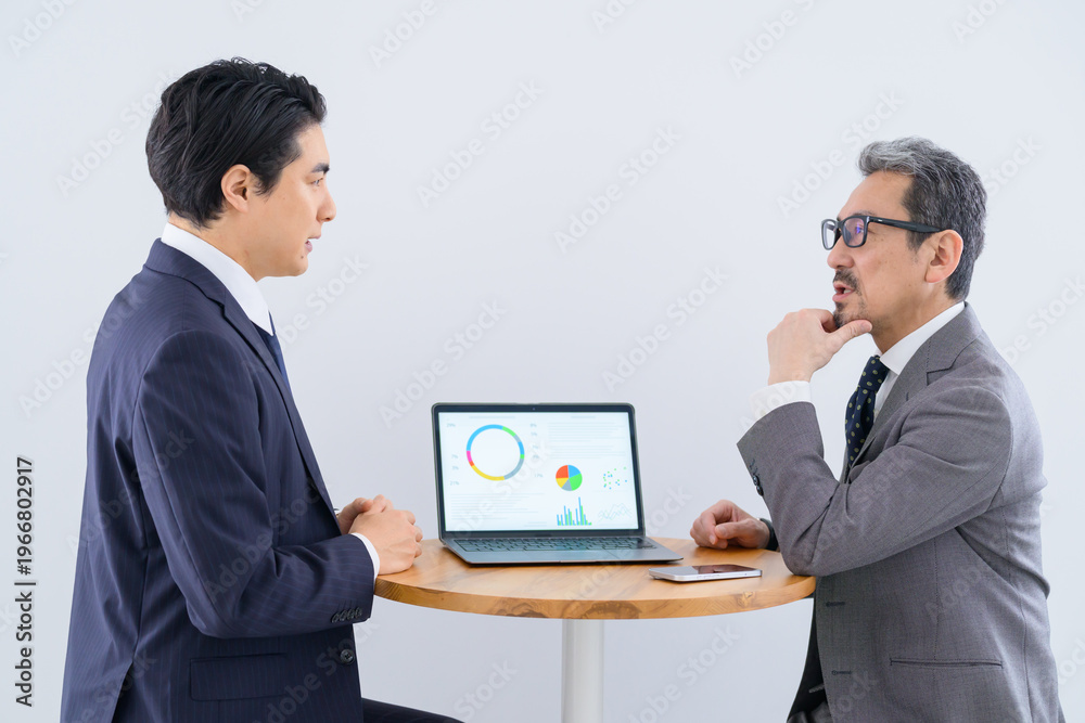 Fototapeta premium ノートパソコンを見ながら打ち合わせをする日本人男性