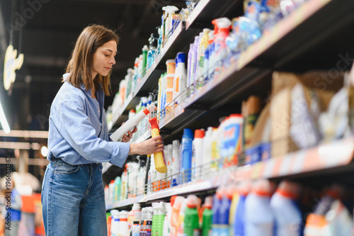 Cuadro en lienzo Woman shopping for cleaning supplies in supermarket aisle