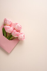 Happy Mother's Day pink tulip bouquet in a pink envelope on a vertical pastel background
