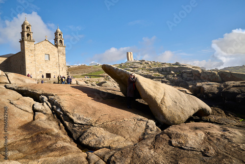 Kidney Stone. Muxía (Spain), March 15, 2026. Tradition attributes healing powers to this stone. In the background, the Sanctuary of Our Lady of the Boat. 