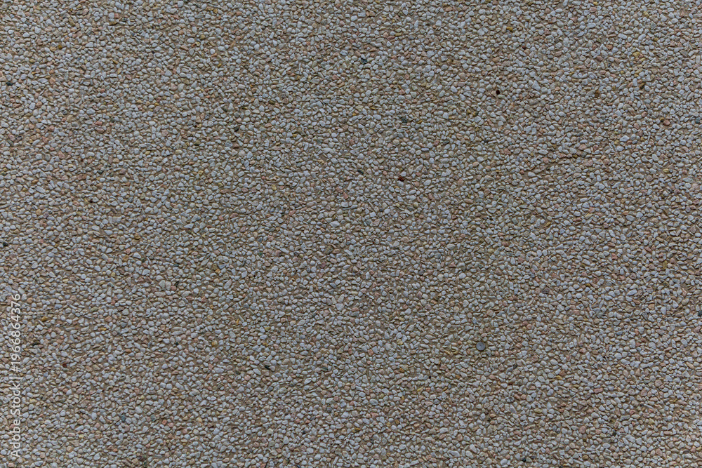 Fototapeta premium Close up of small light pebbles embedded in surface creating a uniform granular texture.