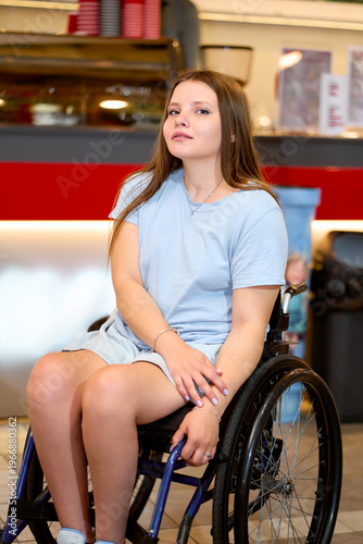 Young Woman in a Wheelchair Sitting in a Modern Coffee Shop Environment