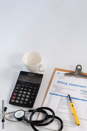 Medical billing statement with calculator stethoscope and coffee cup top view