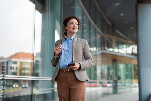 Tableau sur toile Businesswoman looking confidently forward at modern office building