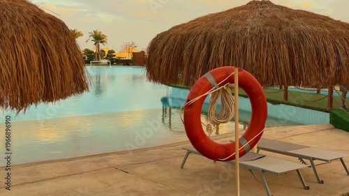Sunset Over Calm Resort Waters. Quiet Lagoon With Relaxing Sunshade And Safety Gear