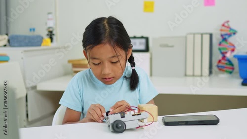 Young girl having fun working on a robot design