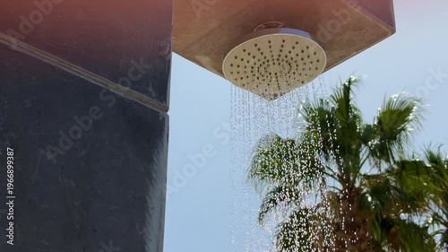 Soothing Waterfall Spray Amid Palm Trees Under Bright Sunlight Creating Peaceful Ambiance