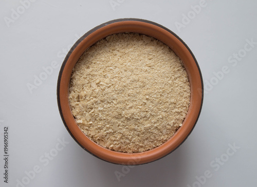 Nutritional deactivated yeast in a bowl on a dark background. Top view. Superfood.