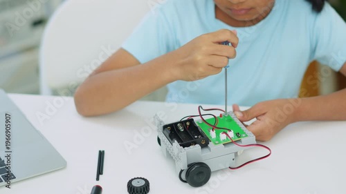 Young girl having fun working on a robot design