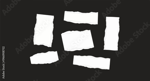 Assortment of torn white paper scraps scattered against a black background