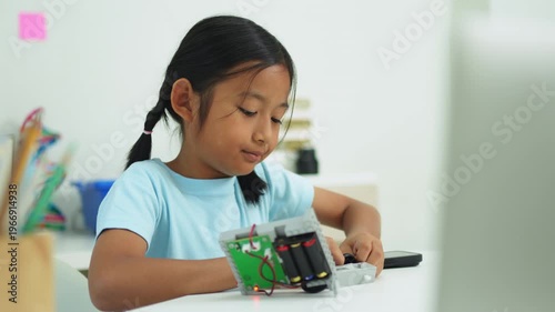Young girl having fun working on a robot design