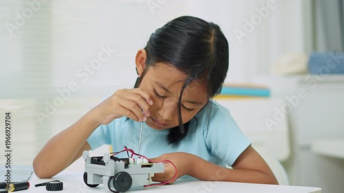 Young girl having fun working on a robot design