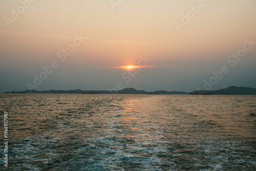 Ship stern cutting through cold waves at golden sunset. Dynamic seascape, travel adventure and maritime lifestyle concept.