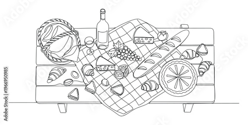 Overhead view of a delicious picnic spread featuring wine, cheese, grapes, baguette, croissants, and sandwiches arranged on a checkered blanket for a perfect outdoor meal experience.