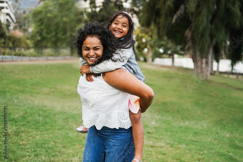 Happy indian mother having fun with her daughter outdoor - Family, mom day and love concept - Main focus on mum face