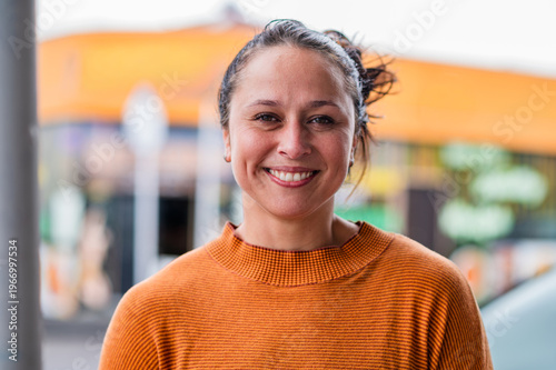 Portrait of an adult woman standing on the streets sidewalk in Auckland smiling