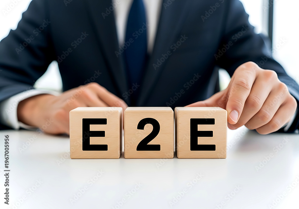 Naklejka premium A business professional arranging wooden blocks that spell out e2e representing end to end business solutions and strategy