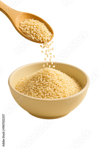 Sesame seeds cascading from a wooden spoon into a beige bowl