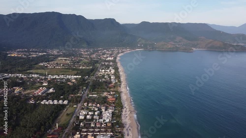 Aerial 4K wide view of Maresias beach coastline and mountains in Sao Sebastiao, Brazil