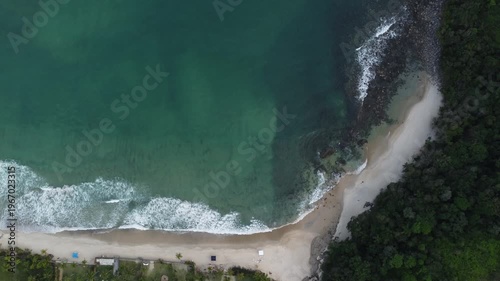 Aerial top down 4K view of Maresias beach coastline and luxury houses on a cloudy day