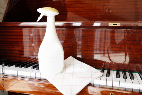 Delicate piano cleaning with spray and cloth keyboard maintenance hygiene and dust removal concept