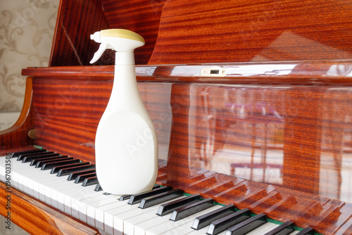 Spray bottle and cloth on piano keyboard cleaning maintenance hygiene and delicate instrument care