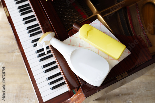 Piano cleaning process with spray bottle and cloth showing hygiene care and dust removal at home