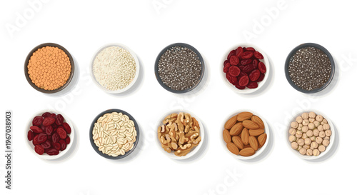 Ten small bowls containing diverse dry food ingredients such as lentils, quinoa, and nuts are arranged in rows on a white background from a top-down view.