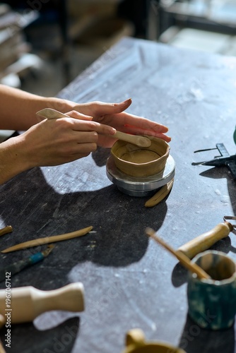 Canvas Print Young woman creating pottery at a vibrant studio filled with artistic tools and