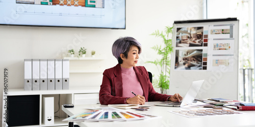 creative designer choosing material and  making interior design on laptop computer in modern office of architectural firm.