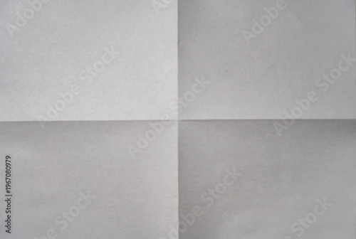 Minimalist background of white paper sheet folded into four quarters with sharp crease lines in the center. Top view of empty aged document texture
