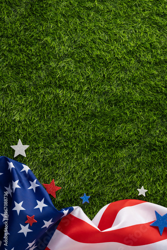 Fotografie Draped vertical American flag and star decorations on fresh grass creating a pat