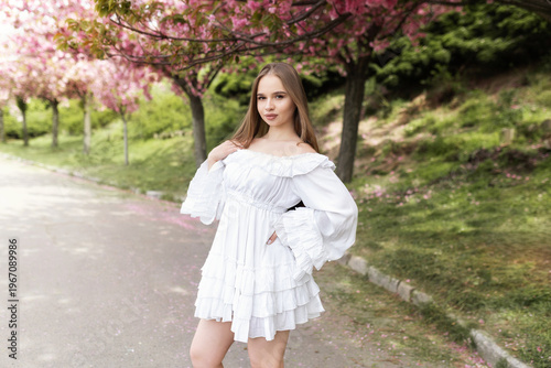 Wallpaper Mural Young beautiful woman in white romantic dress standing under blooming cherry blossom trees in spring garden. spring mood. Perfect for themes of spring, beauty, romance, nature and lifestyle. Torontodigital.ca