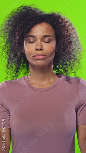 Calm African American woman with curly hair in casual clothing practicing meditation with eyes closed against green backdrop in multiple poses for wellness and mental health focus.