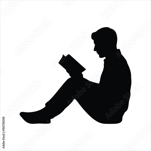 A silhouette of a man sitting and reading a book