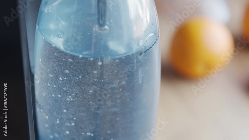 Close-up of sparkling water with bubbles in bottle. Fresh carbonated drink, healthy hydration concept with citrus background.