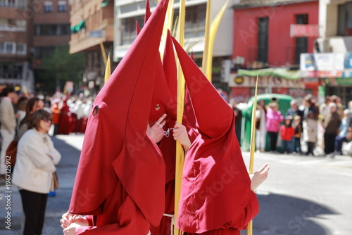 Fotografía Red-hooded Holy Week penitents with palms during Semana Santa procession in Tala