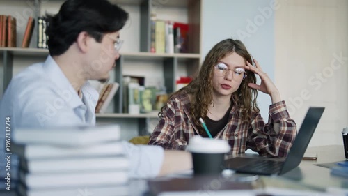 Frustrated college students studying for exams in the university library