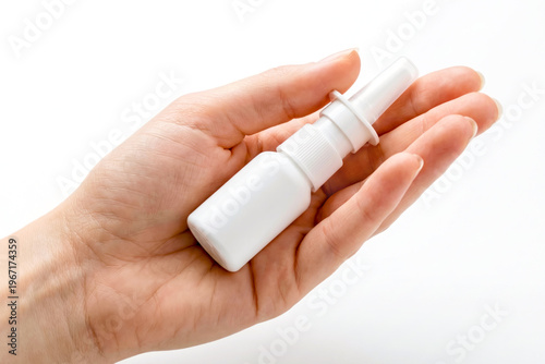 Hand holding a bottle of nasal spray used to relieve breathing and seasonal allergy symptoms caused by pollen. An indispensable medical tool for runny and stuffy noses. 